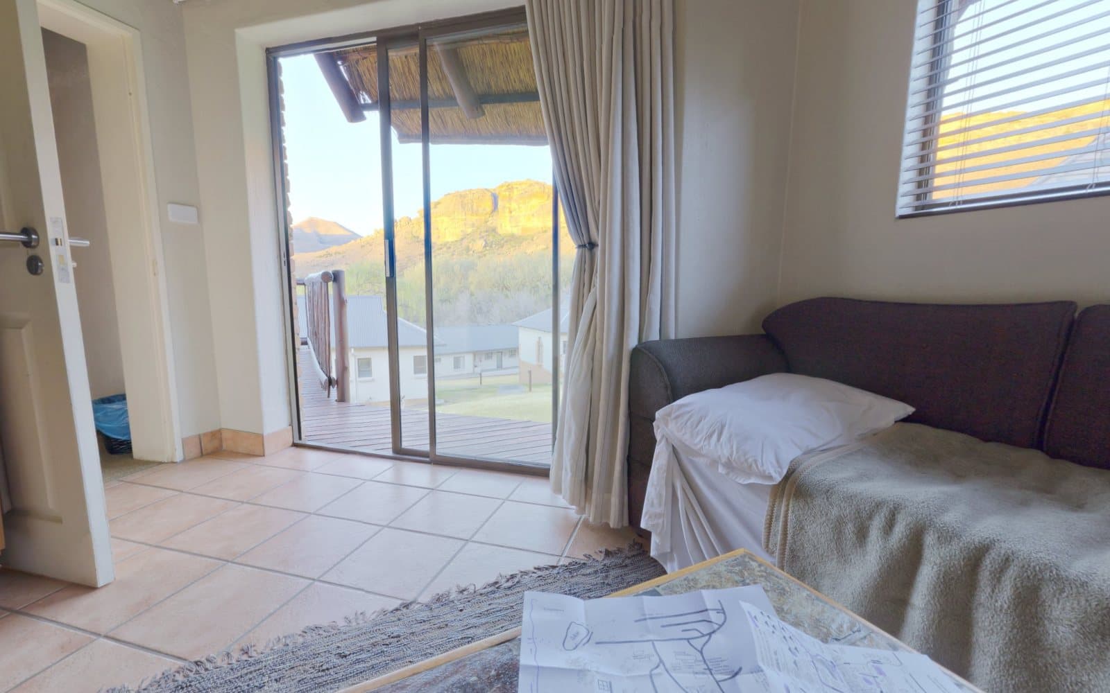 Living room with a patio door open onto a deck and mountains